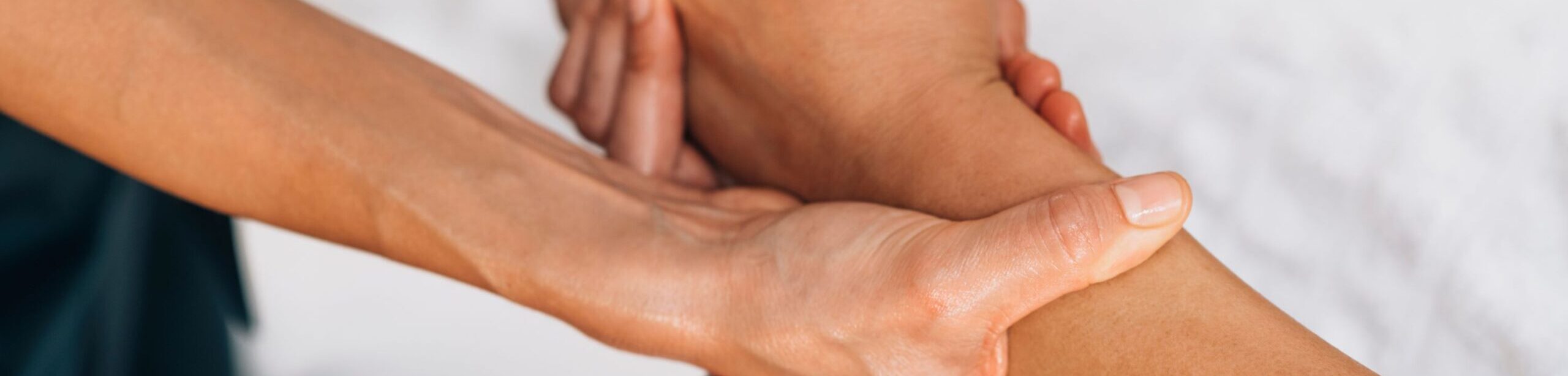 Nahaufnahme einer einfühlsamen Handbehandlung im Rahmen einer komplementärtherapeutischen Sitzung der Kinesiologie Ausbildung an der Apamed.