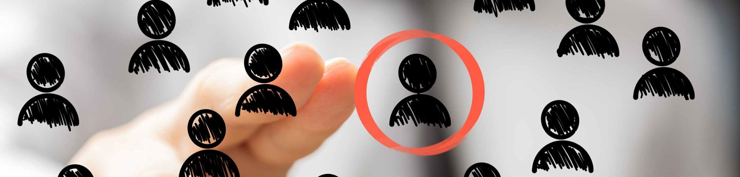 Hand zeigt auf ein gezeichnetes Symbol einer Person, das rot eingekreist ist – Symbolbild für berufliche Identität und Selbstpositionierung.