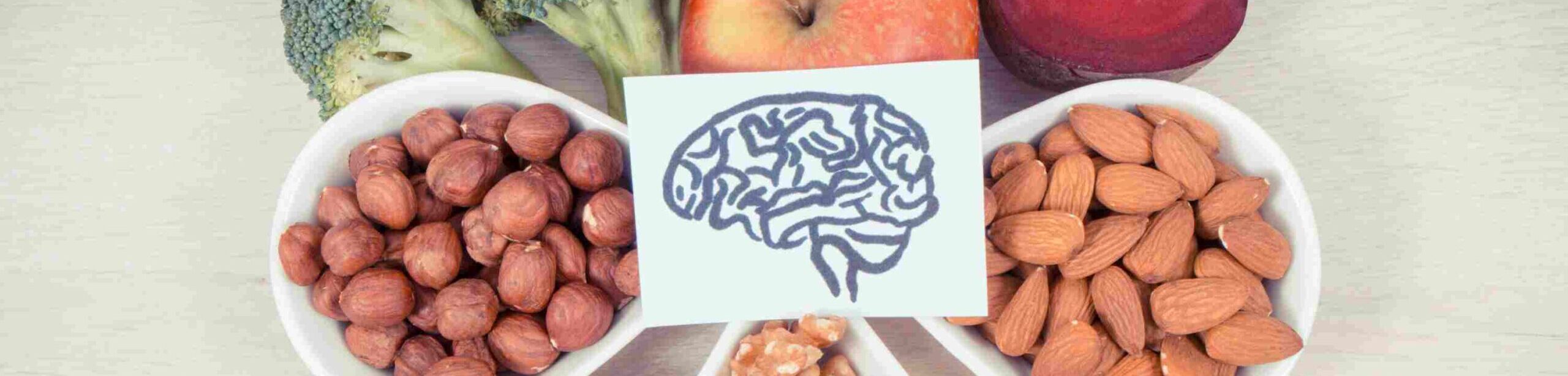 Gesunde Lebensmittel rund um eine stilisierte Gehirngrafik – Symbolbild für Ernährung und Psyche