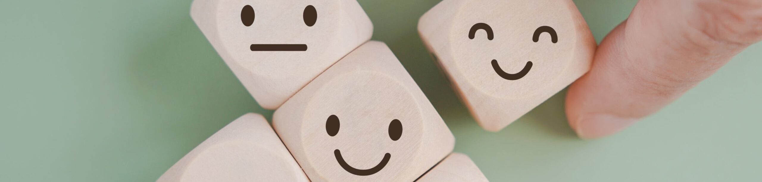 Holzwürfel mit verschiedenen Emotionen – Symbol für systemische Beratung und emotionale Prozesse