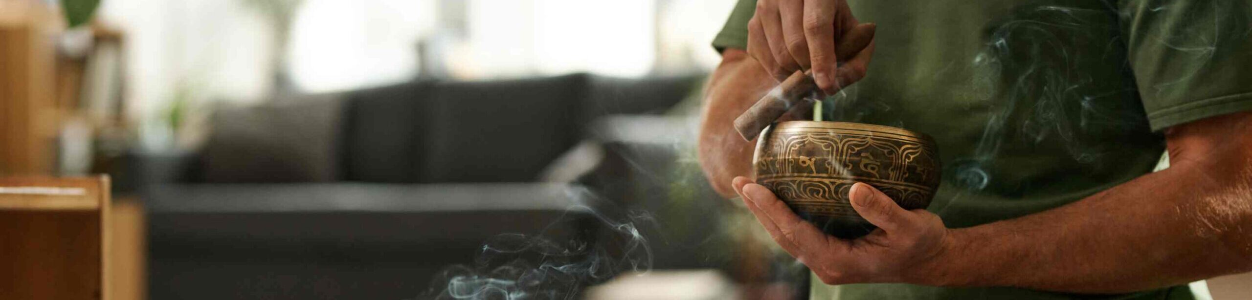 Person nutzt Klangschale in meditativer Sitzhaltung – Anwendung von Klangtherapie zur Entspannung