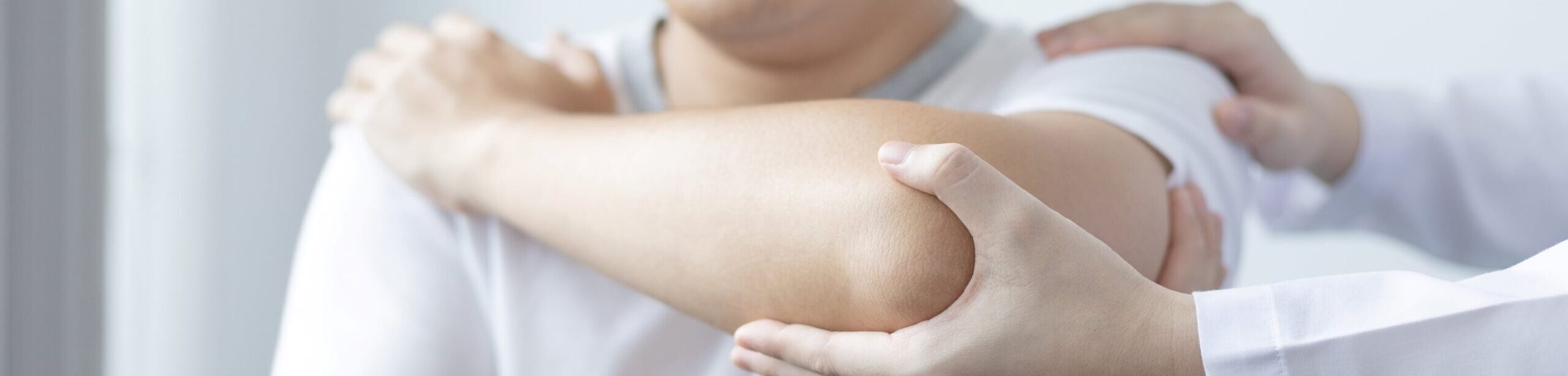 Kinesiologie Ausbildung: Kinesiologische Behandlung am Arm eines Patienten durch Therapeut:in