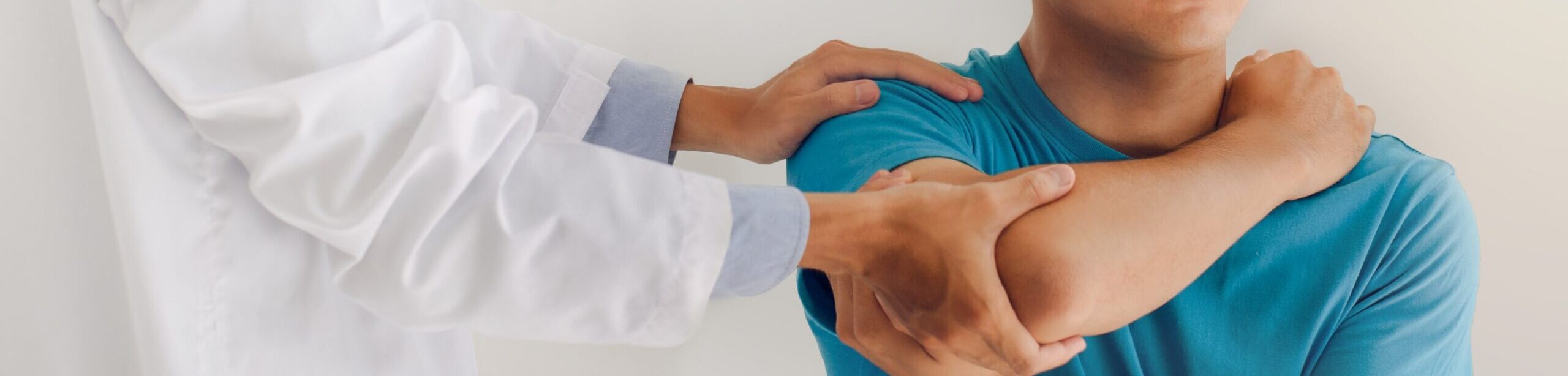 Kinesiologie Ausbildung: Therapeut unterstützt Patient bei Armbewegung – Symbolbild für achtsame Trauma-Arbeit und Körpertherapie