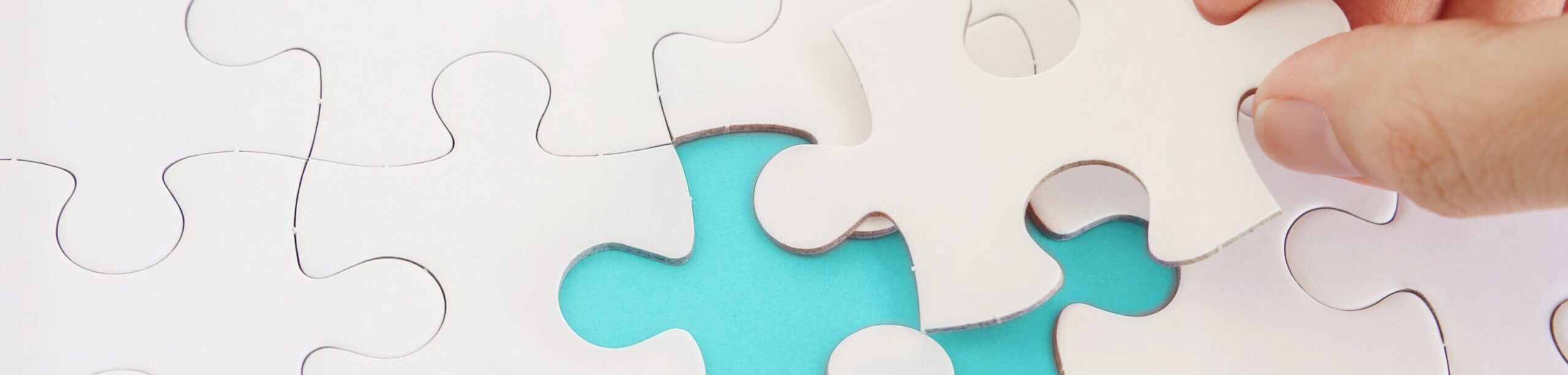 Hand setzt letztes Puzzlestück in ein Puzzle – Symbol für gelungene Kommunikation und psychologisches Verständnis