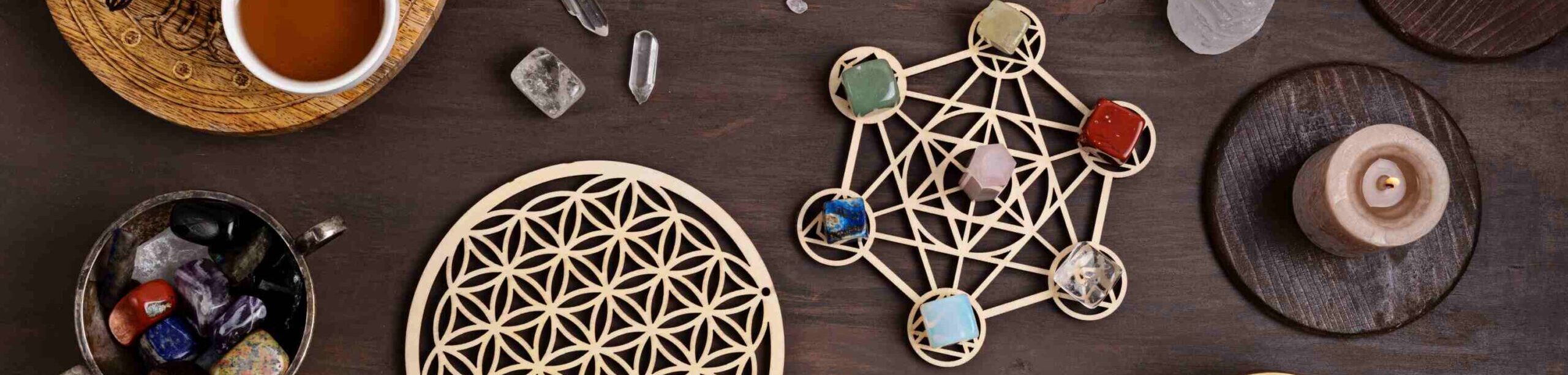 Chakra-Steine, Kristalle und Meditationsobjekte auf einem Holztisch für energetisches Arbeiten
