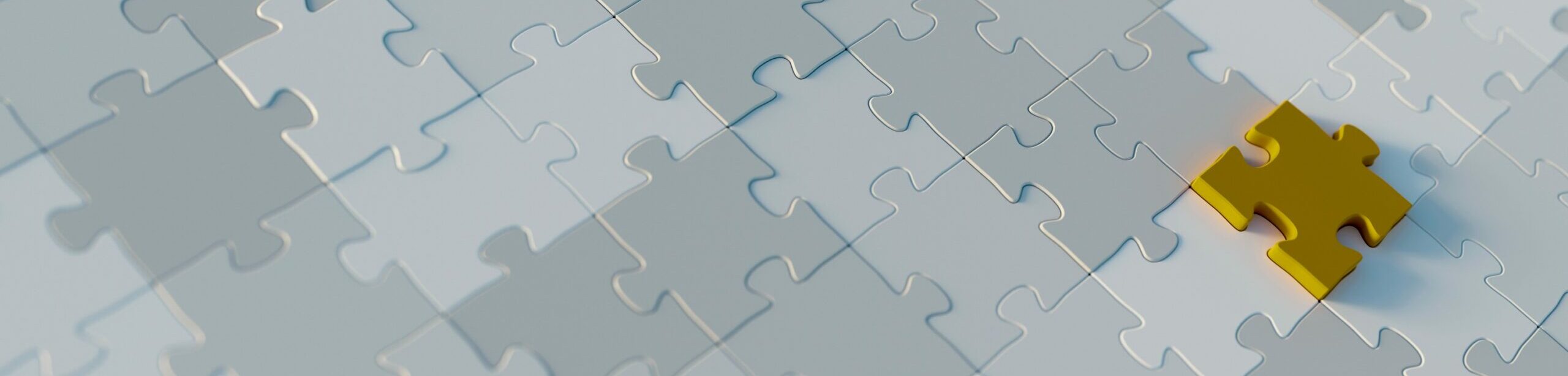 Ein gelbes Puzzlestück liegt als Schlüsselteil auf einem fast fertigen Puzzle