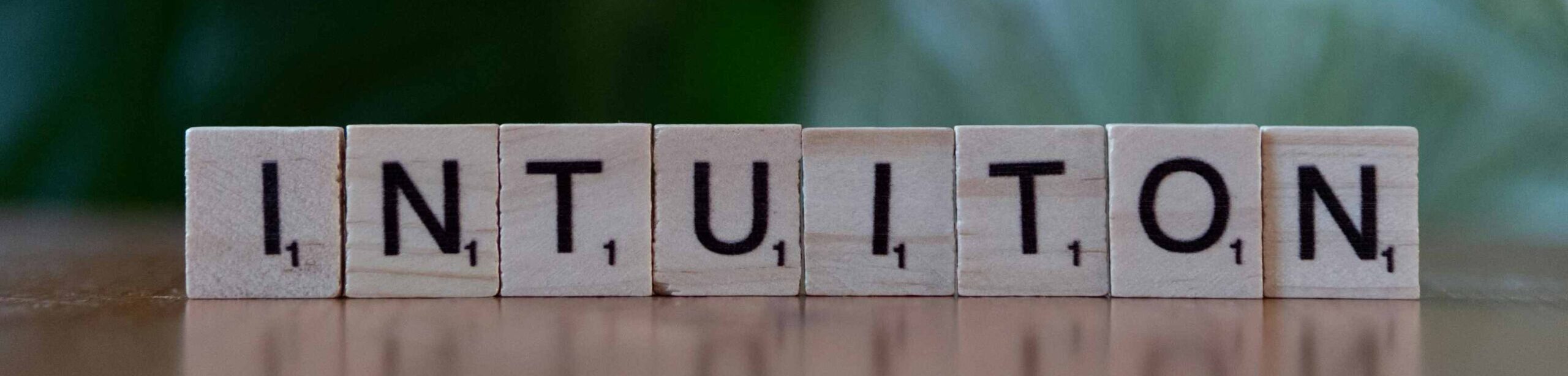 Holzbuchstaben formen das Wort „INTUITION“ – Symbol für innere Stimmen und Selbstwahrnehmung